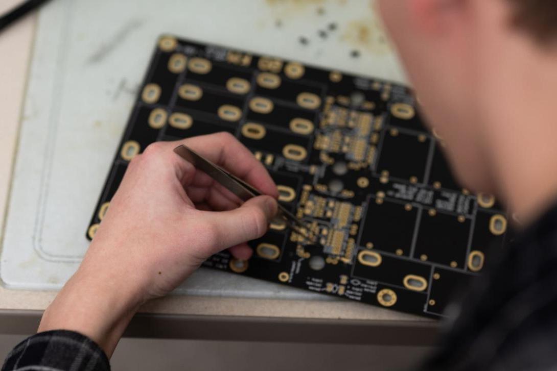 Student working on a circuit board in the Amped Lab