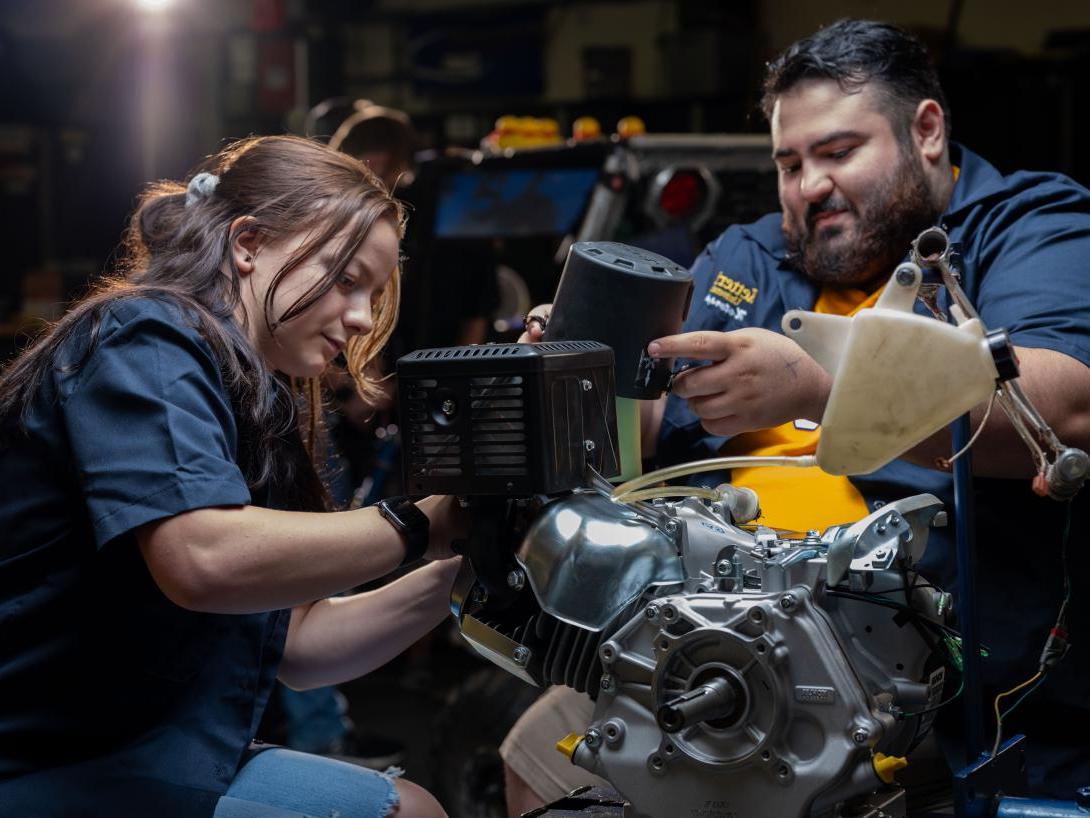 students working on engine in SAE garage